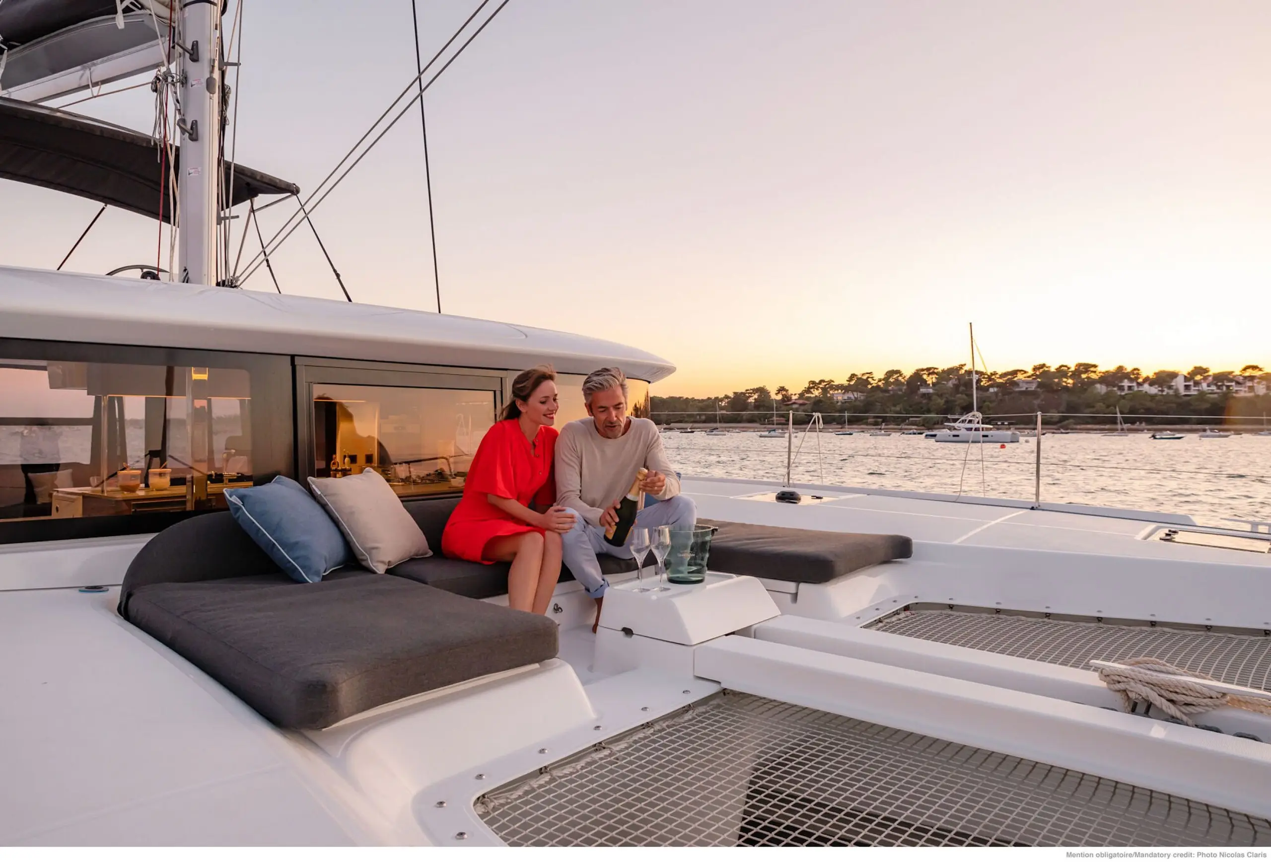 Guests sharing a drink on deck at sunset